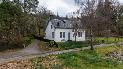 a white house on the side of a road at Rhunacairn in Oban