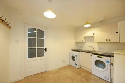 a kitchen with a washing machine and a washer at Branter Lodge in Strachur