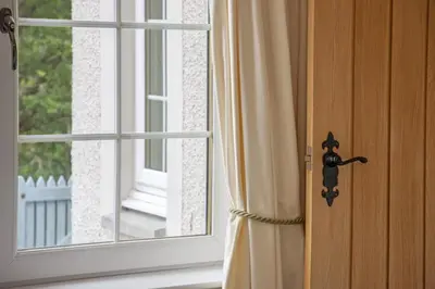 a door with a curtain next to a window at Branter Lodge in Strachur