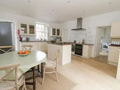 a kitchen with a table with a bowl of fruit on it at Ardchattan Manse in Oban