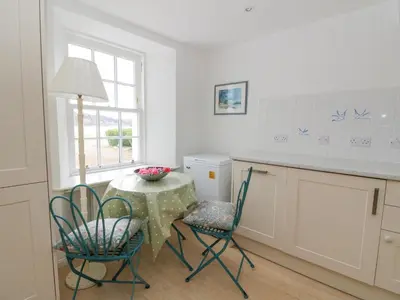 a kitchen with a table and chairs and a window at Ardchattan Manse in Oban
