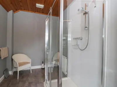 a bathroom with a shower with a glass door at Ardchattan Manse in Oban