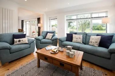 a living room with blue couches and a coffee table at Gaidrew Cottage in Drymen