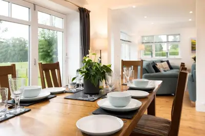 a dining room table with plates and dishes on it at Gaidrew Cottage in Drymen
