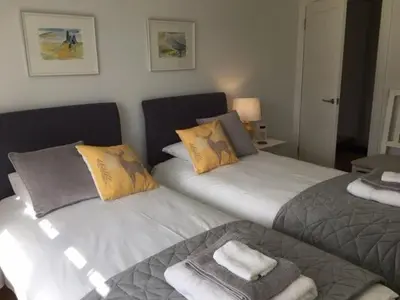 two beds sitting next to each other in a bedroom at Gaidrew Cottage in Drymen