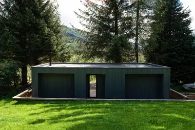 a green building in a field of grass at Am Bothan in Lochearnhead