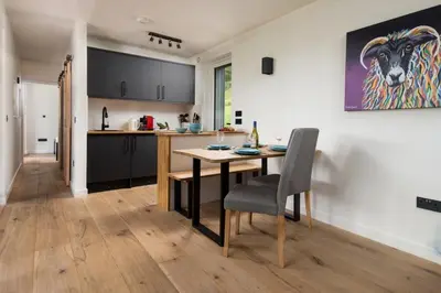 a kitchen with a table and a dining room at Am Bothan in Lochearnhead