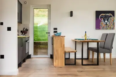 a kitchen with a table and a table and a dining room at Am Bothan in Lochearnhead