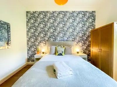 a bedroom with a large bed with a blue blanket at Desirable 2 Bed Apt Near Edinburgh Castle in Edinburgh