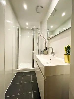 a white bathroom with a sink and a shower at Desirable 2 Bed Apt Near Edinburgh Castle in Edinburgh