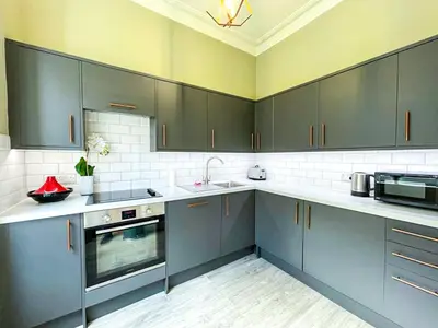 a large kitchen with gray cabinets and a sink at Desirable 2 Bed Apt Near Edinburgh Castle in Edinburgh