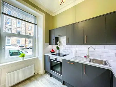 a kitchen with a sink and a large window at Desirable 2 Bed Apt Near Edinburgh Castle in Edinburgh