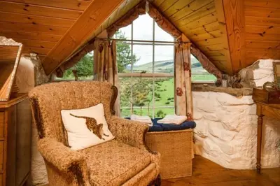 a chair sitting in a room with a window at Strone House in Helensburgh