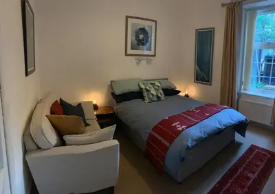 a bedroom with a bed and a couch and a chair at Cedarbank’s - 'Little Art House' in Kirn