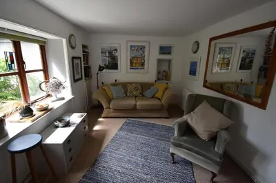 a living room with a couch and chairs and a table at Yewtree Cottage - 'The Art House' and Garden in Hunters Quay