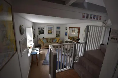 a living room with a staircase and a couch at Yewtree Cottage - 'The Art House' and Garden in Hunters Quay