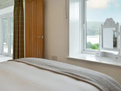 a bedroom with a bed and a window at Boatman's Cottage At Invernian Mor in Inverinan Beg