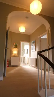 a hallway with a staircase and two lights on the ceiling at Kirkland House B&B in Tarbert