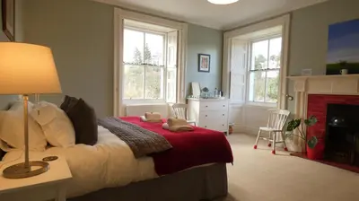 a bedroom with a bed with two teddy bears on it at Kirkland House B&B in Tarbert