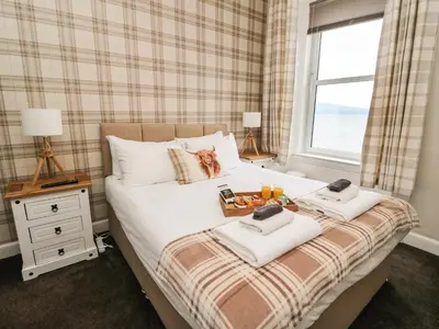 a bedroom with a bed with towels and a window at Argyle House in Rothesay