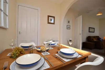 a dining room table with plates and wine glasses at Arran View in Lochgilphead