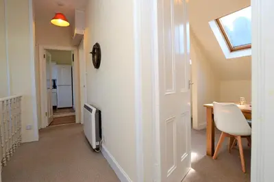 a room with a table and a tv and a door at Arran View in Lochgilphead