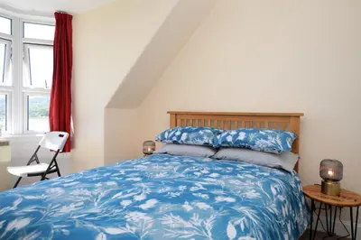 a bedroom with a bed with a blue bedspread at Arran View in Lochgilphead