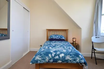 a bedroom with a bed with a blue comforter at Arran View in Lochgilphead