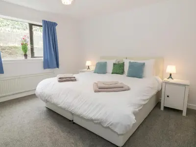 a bedroom with a large white bed with blue pillows at Waters Edge in Stranraer
