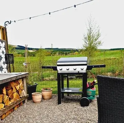a barbecue grill sitting on top of a patio at Romantic Rural Lodge - Private Outdoor Kitchen & Cosy Covered Lounge - Perth and Kinross - Hot Tub not included in Crook of Devon