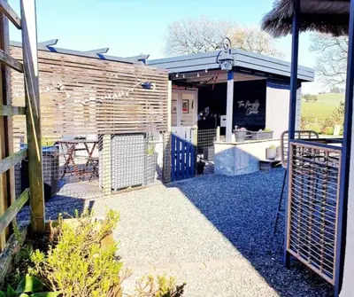 a patio with a grill and a wooden building at Romantic Rural Lodge - Private Outdoor Kitchen & Cosy Covered Lounge - Perth and Kinross - Hot Tub not included in Crook of Devon