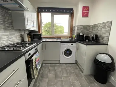 a kitchen with a washing machine and a washer at Pure Apartments Fife - Dunfermline - Pitcorthie in Dunfermline