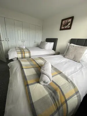 two beds with towels on them in a bedroom at Pure Apartments Fife - Dunfermline - Pitcorthie in Dunfermline