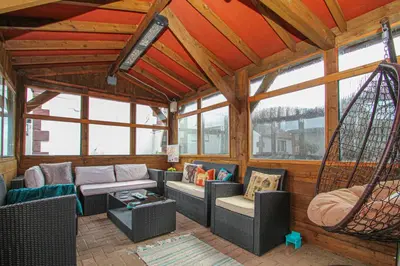 a screened in porch with chairs and a swing at Lotus Studio near Lanark in Carstairs