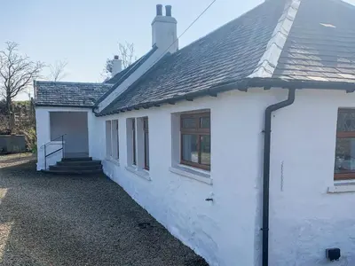 a white house with windows and a roof at Holmbyre Smithy in Dalry