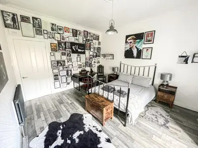 a bedroom with a bed and a bunch of pictures on the wall at Osborne Place in Rothesay