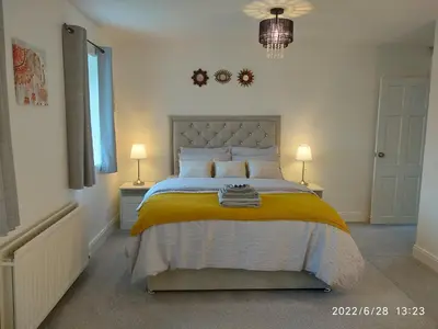 a bedroom with a bed with a yellow blanket at Cottage with Panoramic Views in Kirk of Shotts