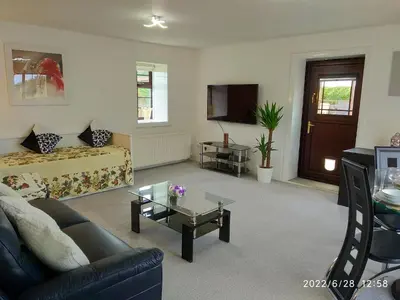 a living room with a couch and a coffee table at Cottage with Panoramic Views in Kirk of Shotts