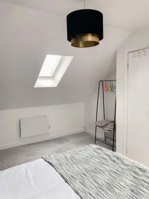 a white bedroom with a bed and a window at Light & Spacious Loch Lomond Apartment in Alexandria