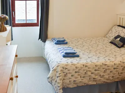 a small bedroom with a bed with towels on it at Bay View in Brodick