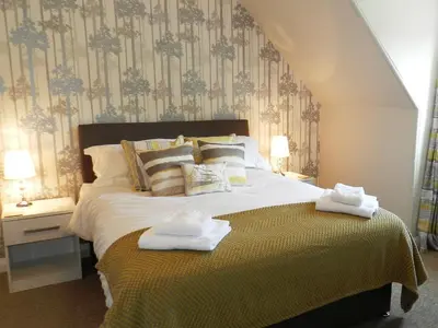 a bedroom with a large bed with towels on it at Larkfield in Lamlash