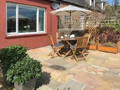 a table and chairs with an umbrella on a patio at Larkfield in Lamlash