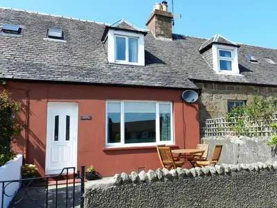 a house with a table and chairs in front of it at Larkfield in Lamlash