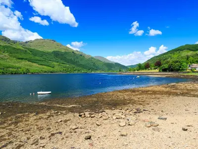 a body of water with a boat on the shore at Glenfruin Lodge in Helensburgh