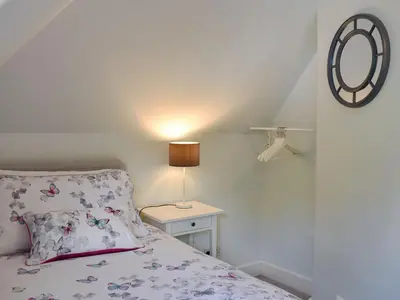 a bedroom with a bed and a mirror on the wall at 1 Hamilton Terrace in Lamlash