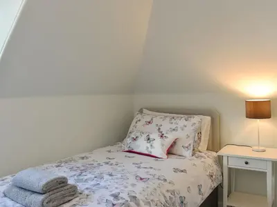a small bedroom with a bed and a night stand at 1 Hamilton Terrace in Lamlash