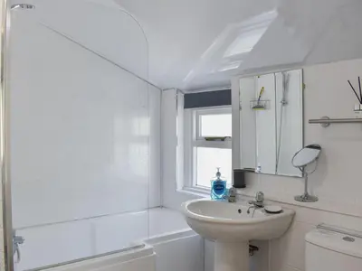a white bathroom with a sink and a mirror at 1 Hamilton Terrace in Lamlash