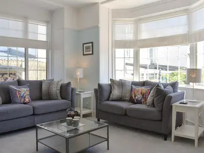 a living room with two couches and a table at 1 Hamilton Terrace in Lamlash