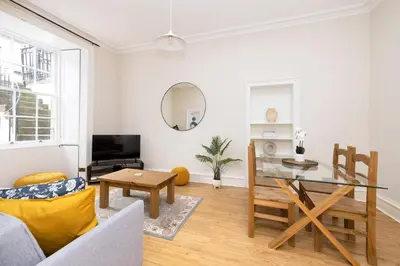 a living room with a table and a couch at JOIVY Chic Apartment near Stockbridge Market in Edinburgh