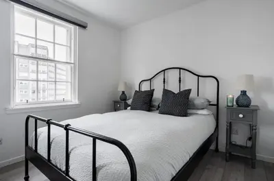 a bedroom with a black and white bed and a window at Edinburgh Castle Apartment G1 in Edinburgh